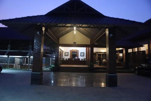 a building with a pavilion in a parking lot at night at GREEN PLANET HOTEL in Mattanūr