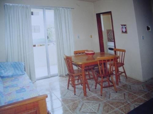 a dining room with a wooden table and chairs at Apart da Cachoeira in Florianópolis