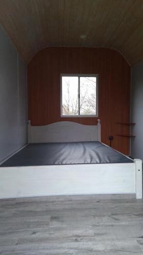 a large bed in a room with a window at Treene Camp Horn in Esperstoft