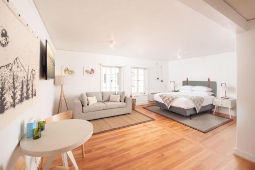SCP Redmond Hotel في ريدموند: غرفة نوم بيضاء مع سرير وطاولة