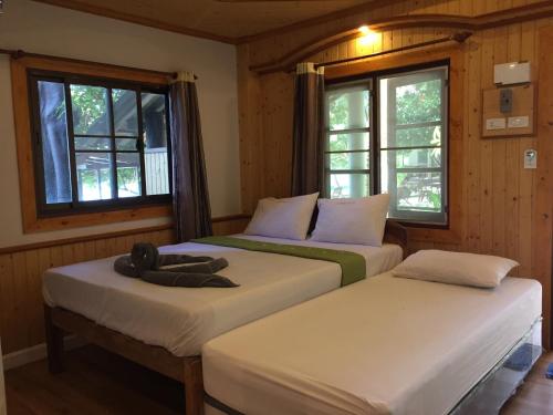 two beds in a room with windows at Big Fish Resort Koh Tao in Koh Tao