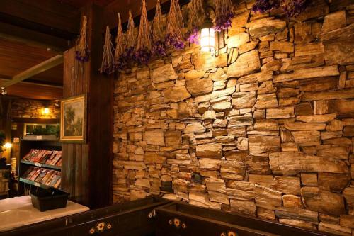 a stone wall in a restaurant with a stone wall at Provence Rose Lodge in Renai