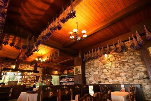 a dining room with tables and a stone wall at Provence Rose Lodge in Renai