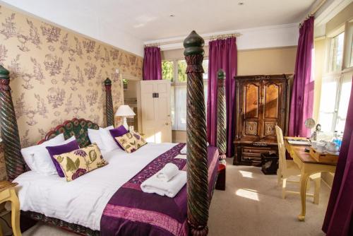 a bedroom with a bed with purple curtains at The William Cecil in Stamford