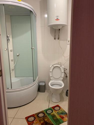 La salle de bains est pourvue de toilettes, d'une douche et d'un tapis. dans l'établissement 32Kotliarska, à Lviv