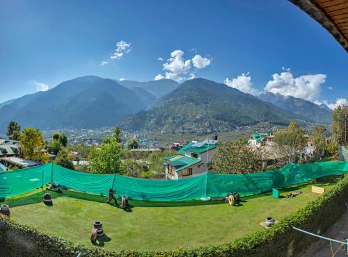 a view of a park with mountains in the background at Club Mahindra White Meadows Manali in Nagar