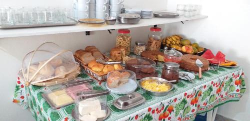 Una mesa con muchos tipos diferentes de comida sobre ella. en Pousada Mama Jo, en Casimiro de Abreu