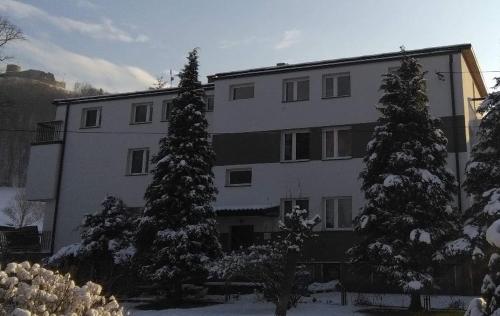 a large white building with trees in front of it at Apartamenty „Nad Popradem” in Rytro