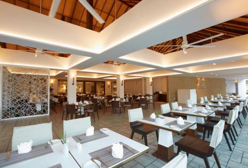 七岩的住宿－Veranda Resort & Villas Hua Hin Cha Am，一间餐厅,房间内设有白色的桌椅