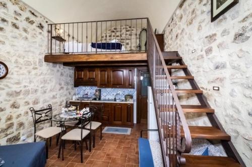 a kitchen with a staircase and a table in a room at U Dammusu in Modica