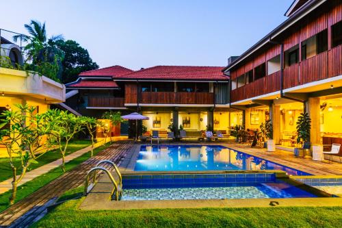 una piscina del complejo frente a un edificio en Seahorse Hotel & Spa en Negombo