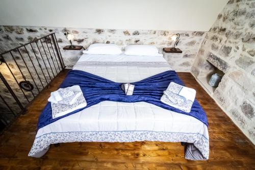 a bedroom with a bed with blue and white sheets at U Dammusu in Modica