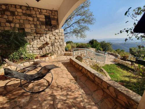 a patio with a bench and a stone wall at Switzerland In Amirim in Amirim