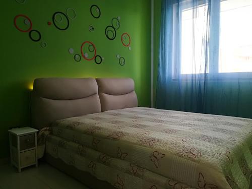 - une chambre avec un lit et un mur vert avec une fenêtre dans l'établissement Virginia Otranto holiday home 4 places, à Otrante
