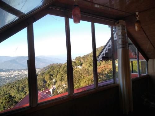 een raam met uitzicht op een berg bij Bethany Homestay in Kalimpong