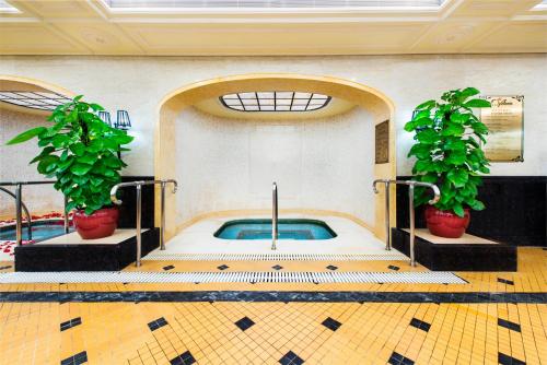 a swimming pool with two potted plants in a building at Harbourview Hotel Macau in Macau
