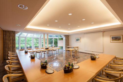 a conference room with tables and chairs and a whiteboard at Hotel Heidehof garni in Büdelsdorf
