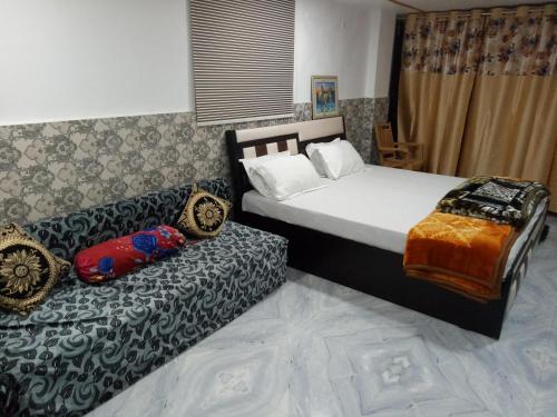 um quarto com uma cama e um sofá em Traveller Guest House em Varanasi