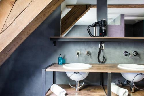 a bathroom with two sinks in a loft at Van Rossum Stadshotel Woerden in Woerden