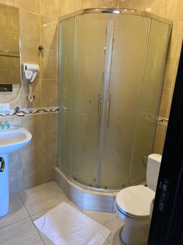 a bathroom with a shower and a toilet and a sink at 7 Baits Hotel in Tbilisi City