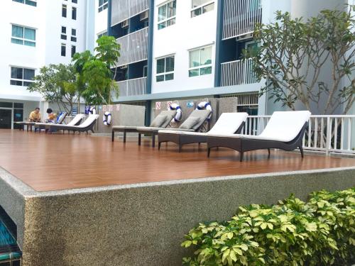 a row of chairs sitting on a balcony in a building at The Trust Condo Huahin by Petcharat in Hua Hin