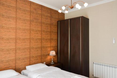 a bedroom with two beds and a wooden wall at Eleon Boutique Hotel in Tbilisi City