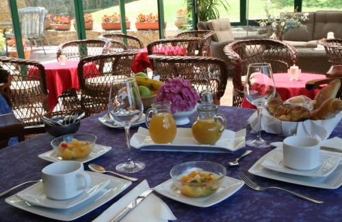 a table with plates of food and glasses of orange juice at Hotel Palacio De La Viñona in Oviedo