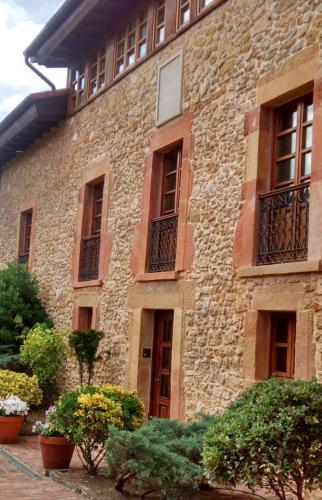 a stone building with windows and plants in front of it at Hotel Palacio De La Viñona in Oviedo