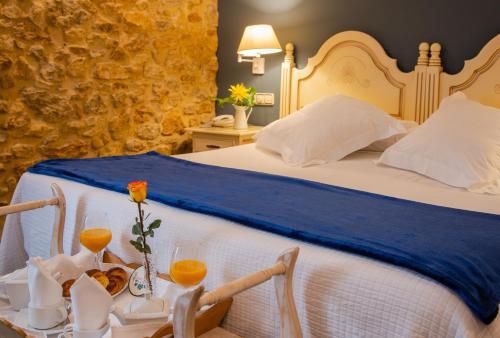 ein Hotelzimmer mit einem Bett mit blauer Tagesdecke in der Unterkunft Hotel Palacio De La Viñona in Oviedo