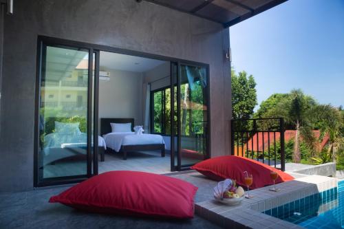 two red pillows sitting next to a swimming pool at T villas in Thong Nai Pan Yai