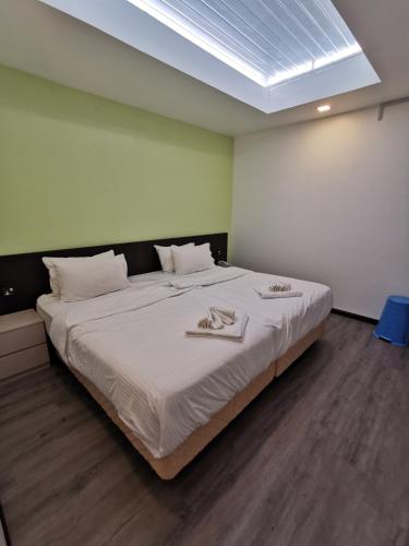 a bedroom with a large bed with white sheets at TT Dorf Hotel Matang in Taiping