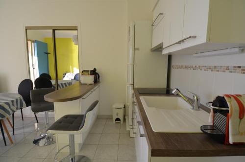 a kitchen with a sink and a counter with chairs at Appartement 4 personnes avec Vue Mer exceptionnelle à Villefranche-sur-Mer in Villefranche-sur-Mer