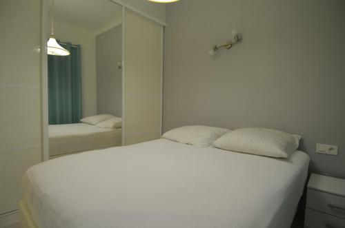 1 dormitorio con cama blanca y espejo en Appartement 4 personnes avec Vue Mer exceptionnelle à Villefranche-sur-Mer, en Villefranche-sur-Mer