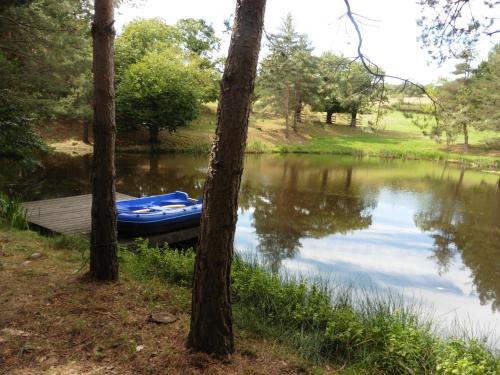 un bateau assis sur le côté d'un lac dans l'établissement Le Petit Rias Gîte Soleil, à Saint Maurice en Chalencon