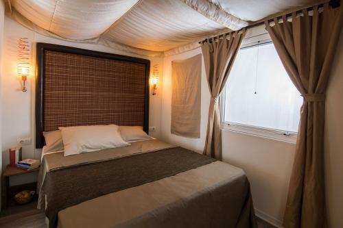 a bedroom with a bed with a large window at Camping Barco Reale in Lamporecchio