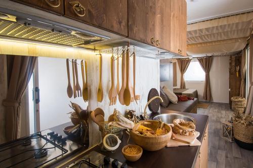 a kitchen with utensils hanging from the wall at Camping Barco Reale in Lamporecchio