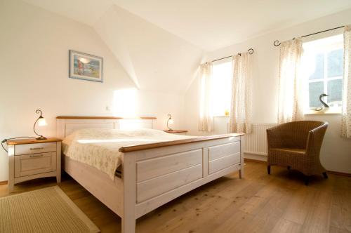 1 dormitorio con 1 cama blanca y 1 silla en Ferienhaus Zander mit Sauna, en Born
