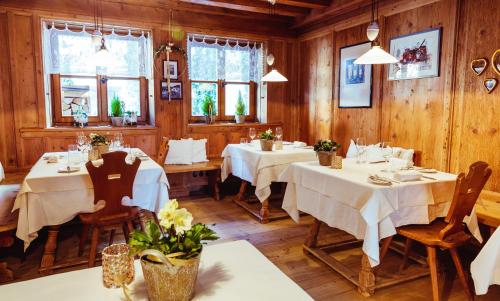 a dining room with tables and chairs and wooden walls at Gourmet - Boutique Hotel Tanzer in Falzes