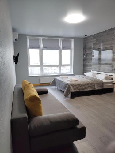 a living room with a couch and a bed at Solo Apartment Kamenskaya in Kyiv