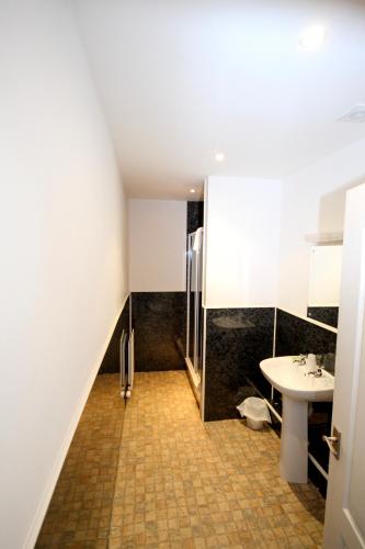 a bathroom with a sink and a shower and a toilet at The Kings Arms in Shap