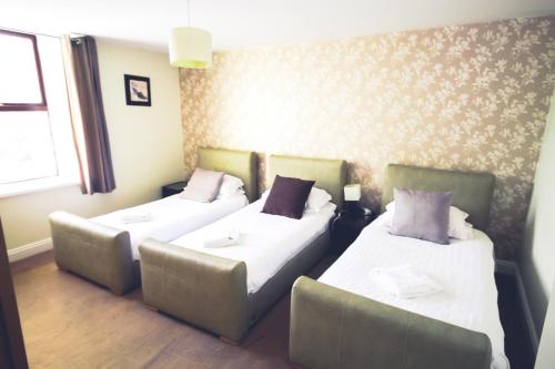 a room with two beds and a couch at The Kings Arms in Shap