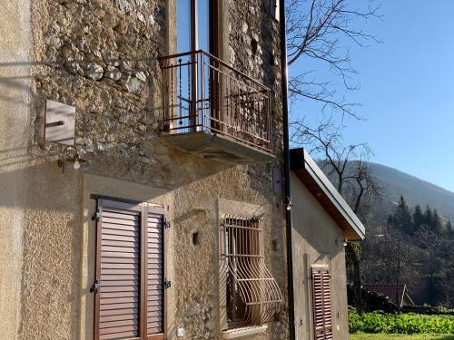 a building with a balcony and a door and a window at Tenuta Novecento Bioagriturismo in Agerola