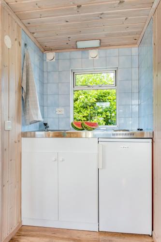 a kitchen with white cabinets and a window at First Camp Kärradal-Varberg in Varberg