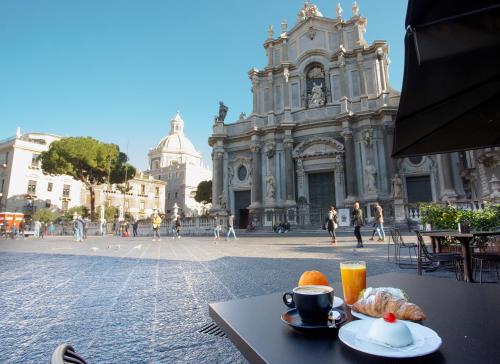 Duomo Luxury Suite Catania في كاتانيا: طاولة عليها طعام أمام مبنى