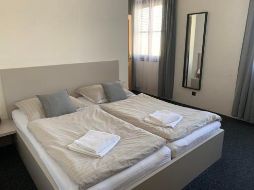 a large bed with white sheets and towels on it at Penzion Nové Odry in Odry