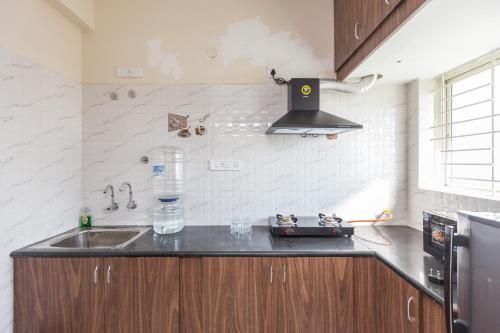 a kitchen with a sink and a stove at Misty Meridian Serviced Apartments in Bengaluru