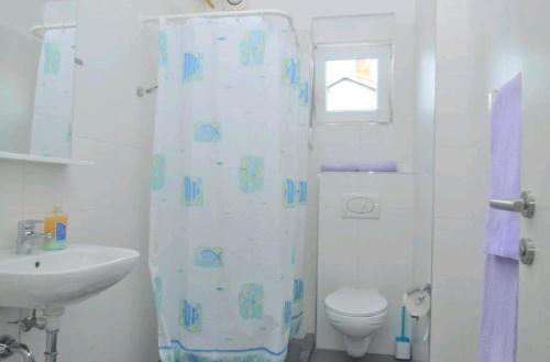 ein Bad mit einem WC und einem Duschvorhang in der Unterkunft Urnebes in Zadar