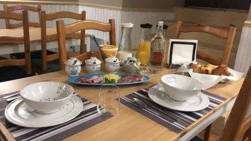 Una mesa con dos cuencos y un plato de comida. en Les Sorbiers Barèges, en Barèges