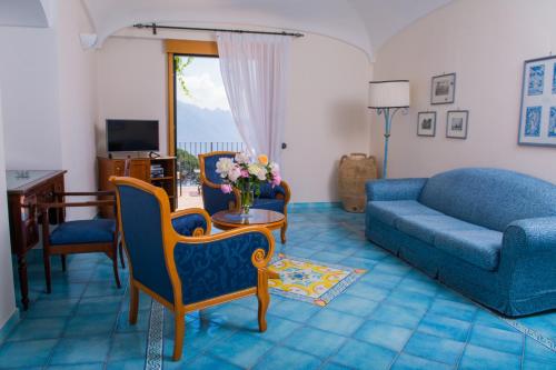 a living room with a couch and a table and chairs at Hotel Rufolo in Ravello