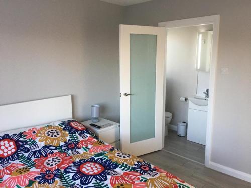 1 dormitorio con 1 cama con un edredón colorido en Byrestown Cottage en Kells